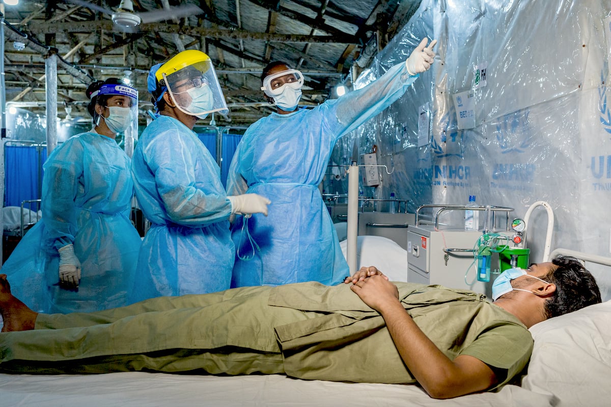 WHO Infection Prevention and Control Specialist Rebecca Rachel Apolot, center, visits a COVID-19 patient shortly before he is discharged from a Severe Acute Respiratory Infection Isolation and Treatment Center (SARI ITC) facility