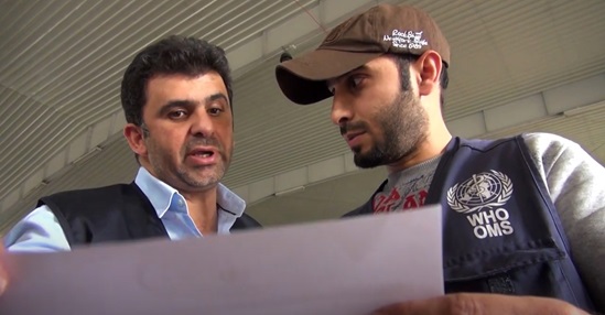 Two WHO staff looking at a document and discussing.