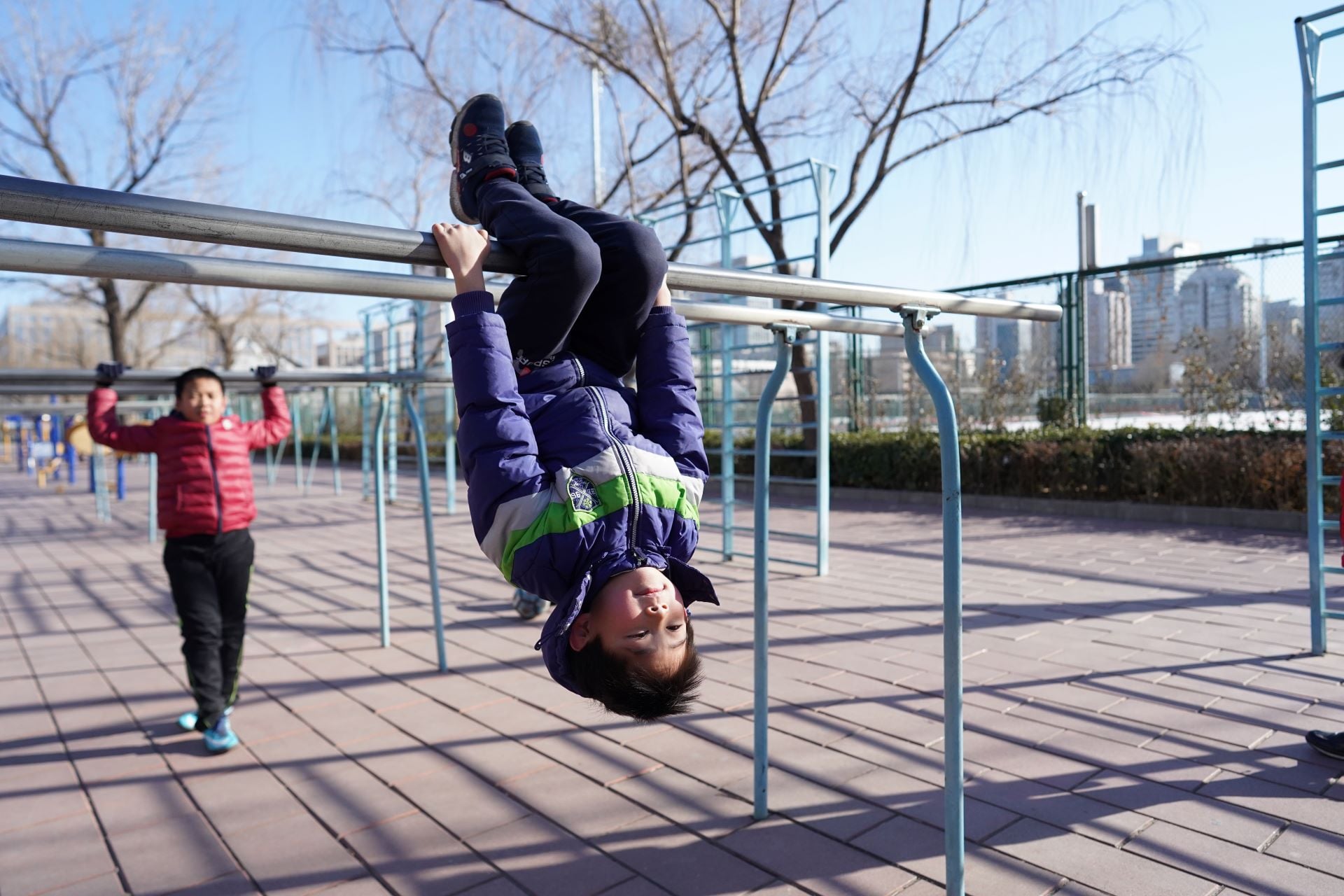 Boys using fitness equipment outside in Beijing